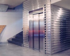 Neugestaltung der Innenräume für das Haus der Musik in Triest Foto des Eingangsbereichs mit Detail der Aufzugsverblendung