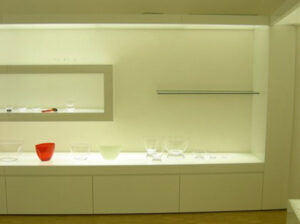 Neugestaltung des Italesse Showrooms, eine Handelsfirma für Gläser und Weinzubehör Foto des Ausstellungssystems: beleuchtende Regale mit Schubfächer